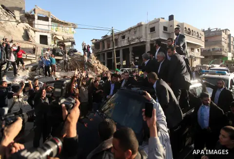 Hamas chief Khaled Meshaal, riding in a car with Palestinian prime minister in Gaza Strip Ismail Haniyeh, waves to the crowd upon his arrival in Gaza City December 7, 2012. Meshaal is making his first-ever visit to the G...