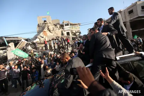 Hamas chief Khaled Meshaal, riding in a car with Palestinian prime minister in Gaza Strip Ismail Haniyeh, waves to the crowd upon his arrival in Gaza City December 7, 2012. Meshaal is making his first-ever visit to the G...