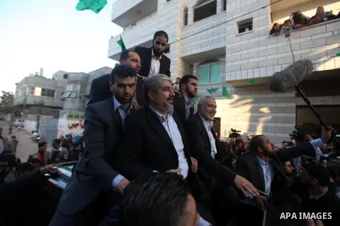 Hamas chief Khaled Meshaal, riding in a car with Palestinian prime minister in Gaza Strip Ismail Haniyeh, waves to the crowd upon his arrival in Gaza City December 7, 2012. Meshaal is making his first-ever visit to the G...