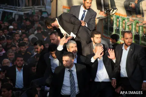 Hamas chief Khaled Meshaal, riding in a car with Palestinian prime minister in Gaza Strip Ismail Haniyeh, waves to the crowd upon his arrival in Gaza City December 7, 2012. Meshaal is making his first-ever visit to the G...