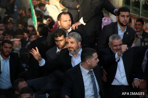 Hamas chief Khaled Meshaal, riding in a car with Palestinian prime minister in Gaza Strip Ismail Haniyeh, waves to the crowd upon his arrival in Gaza City December 7, 2012. Meshaal is making his first-ever visit to the G...