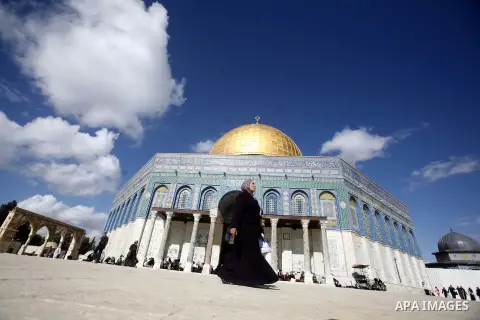 Palestinian Woman walk in front of the dome of the rock and Al Aqsa mosque in the old city of Jerusalem on December 7, 2012. Photo by Mahfouz Abu Turk