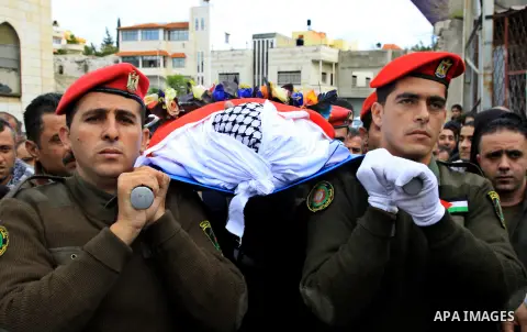 Palestinian security forces carry the body of 37-year-old Hatem Shadid, who was shot dead by members of the Israeli internal security agency after ramming their car and attacking them with an axe in the West Bank area of...