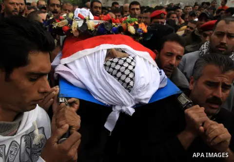 Palestinians carry the body of Hatem Shadid, who was shot dead by Israeli officers on December 3, during his funeral in the West Bank village of Alar, near Tulkarem December 7, 2012. Shadid, rammed an Israeli army jeep c...