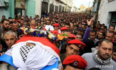 Palestinians carry the body of Hatem Shadid, who was shot dead by Israeli officers on December 3, during his funeral in the West Bank village of Alar, near Tulkarem December 7, 2012. Shadid, rammed an Israeli army jeep c...