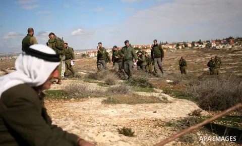 Israel soldiers stand guards as they prevent Palestinians from reaching their farming lands near the Jewish settlement of Sosia in the West Bank city of Hebron on December 7,2012. Israel intends to carry out extensive bu...