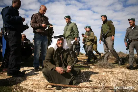 Israel soldiers stand guards as they prevent Palestinians from reaching their farming lands near the Jewish settlement of Sosia in the West Bank city of Hebron on December 7,2012. Israel intends to carry out extensive bu...