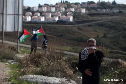 A Palestinian protester runs from tear gas during clashes following a demonstration against the expropriation of Palestinian land by Israel in the West Bank village of Nabi Saleh on December 7, 2012. Photo by Issam Rimaw...