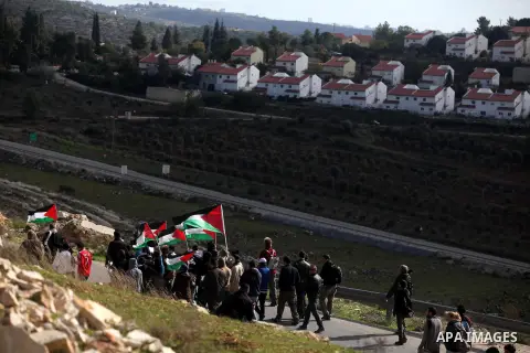 Palestinian Youth holds a poster of Hatem Shadid (L) who killed by Israeli soldier (R), during clashes following a demonstration against the expropriation of Palestinian land by Israel in the West Bank village of Nabi Sa...