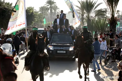 Hamas chief Khaled Meshaal waves to the crowd from his car beside senior Hamas leader Ismail Haniyeh at the Rafah Crossing, in southern Gaza Strip December 7, 2012. Meshaal ended decades of exile from Palestinian land on...