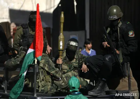 Masked Hamas security men stand guard during a Hamas rally marking the 25th anniversary of the Islamist movement's founding in Gaza City on December 8, 2012. Hamas chief Khaled Meshaal arrived to Gaza strip on December 7...