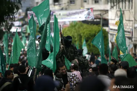 Masked Hamas security men stand guard during a Hamas rally marking the 25th anniversary of the Islamist movement's founding in Gaza City on December 8, 2012. Hamas chief Khaled Meshaal arrived to Gaza strip on December 7...