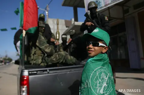 Masked Hamas security men stand guard during a Hamas rally marking the 25th anniversary of the Islamist movement's founding in Gaza City on December 8, 2012. Hamas chief Khaled Meshaal arrived to Gaza strip on December 7...