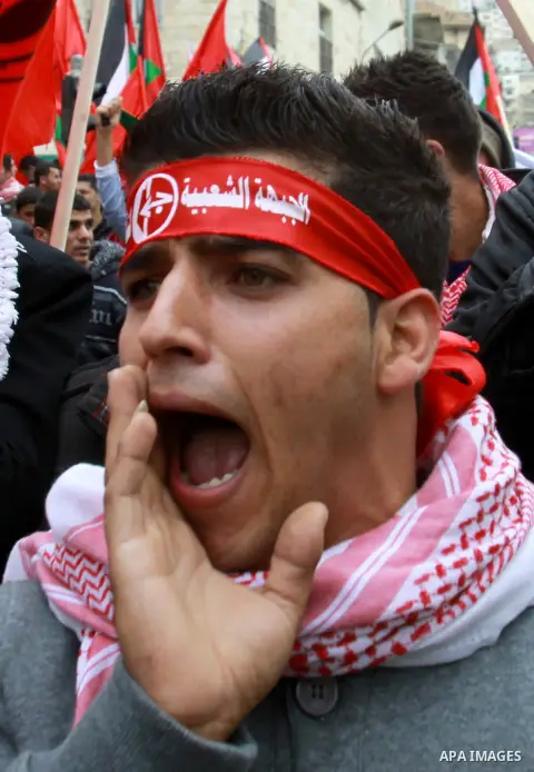 Supporters of the Popular Front for the Liberation of Palestine (PFLP) carry the party flag during a rally to mark the 45th anniversary of the establishment of the PFLP in the West Bank city of Nablus on December 8, 2012...