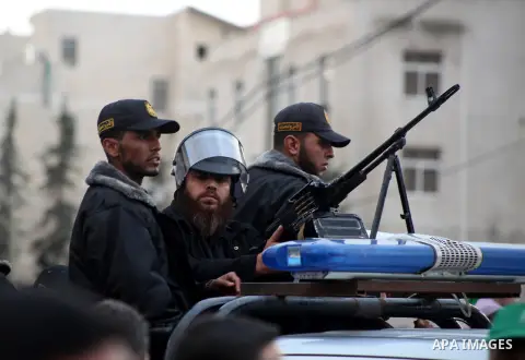 Masked Hamas security men stand guard during a Hamas rally marking the 25th anniversary of the Islamist movement's founding in Gaza City on December 8, 2012. Hamas chief Khaled Meshaal arrived to Gaza strip on December 7...