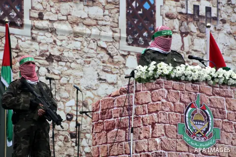 A Palestinian member of the Ezzedine al-Qassam brigades, the armed wing of Hamas, speaks during a Hamas rally marking the 25th anniversary of the Islamist movement's founding in Gaza City on December 8, 2012. Hamas chief...
