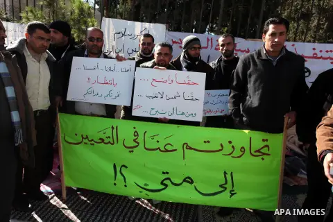 Palestinian teachers and graduates who were barred from employment by Ministry of Education, hold placards during a protest in front of Council of Ministers, in the West Bank city of Ramallah, December 09, 2012 . Photo b...
