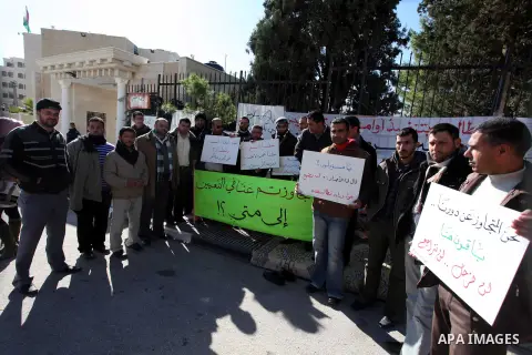Palestinian teachers and graduates who were barred from employment by Ministry of Education, hold placards during a protest in front of Council of Ministers, in the West Bank city of Ramallah, December 09, 2012 . Photo b...