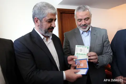 Palestinian Prime Minister in Gaza strip Ismail Haniyeh gives Hamas leader in exile Khaled Meshaal a diplomatic Palestinian passport, upon his departure from the Gaza Strip on December 10, 2012. Exiled Hamas chief Khaled...