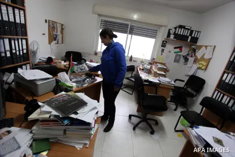 An employee checks a desk at the offices of the Addameer (Arabic for conscience) Prisoner Support and Human Rights offices, in the West Bank city of Ramallah, on December 11, 2012, after Israeli forces raided the offices...