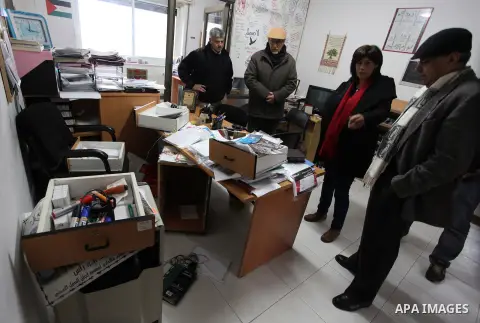 Palestinian employees check a desk at the offices of the Addameer (Arabic for conscience) Prisoner Support and Human Rights offices, in the West Bank city of Ramallah, on December 11, 2012, after Israeli forces raided th...