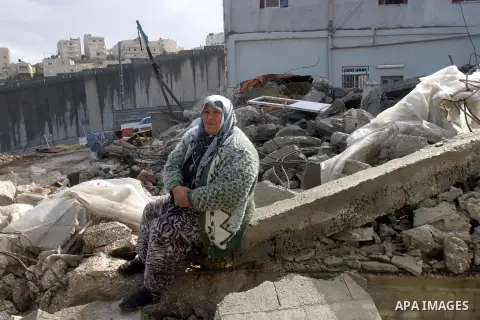 A Palestinian woman from Jabari family sits on the rubble of their house after it was demolished by Jerusalem municipality workers in the mostly Arab east Jerusalem neighborhood of al-Tur on December 11, 2012. Palestinia...