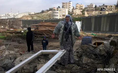 Member of the Palestinian Jabari family are seen close to the rubble of their house after it was demolished by Jerusalem municipality workers in the mostly Arab east Jerusalem neighborhood of al-Tur on December 11, 2012....