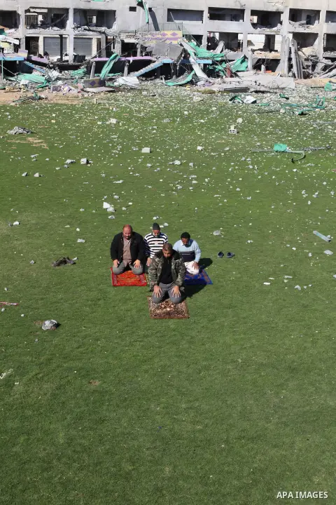 Palestinian security guards pray at a soccer stadium, which witnesses said was destroyed in an Israeli air strike during an eight-day conflict, in Gaza City December 4, 2012. Eight days of Israeli air strikes on Gaza and...