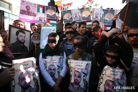 Protesters hold portraits of Samer Issawi and Ayman Sharwanah, Palestinian prisoners held in Israeli jails and on hunger strike, during a solidarity protest in the West Bank city of Hebron, December 12, 2012. Demonstrato...