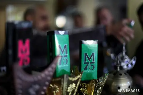 A Palestinian vendor displays perfume bottles called M75 at his shop in Gaza City December 12, 2012. The Gaza vendor said the new perfume symbolises the name of the home-made M75 rocket. Hamas' armed wing said they had f...