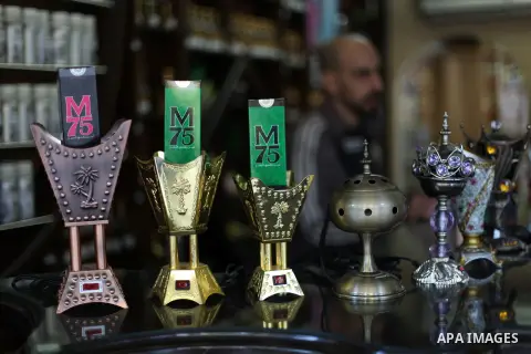 A Palestinian vendor displays perfume bottles called M75 at his shop in Gaza City December 12, 2012. The Gaza vendor said the new perfume symbolises the name of the home-made M75 rocket. Hamas' armed wing said they had f...