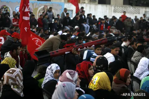 A Palestinian youth carries a model of a locally made rocket during a rally organized by the Popular Front for the Liberation of Palestine (PFLP) to mark the 45th anniversary of the founding of the PFLP in Khan Younis so...