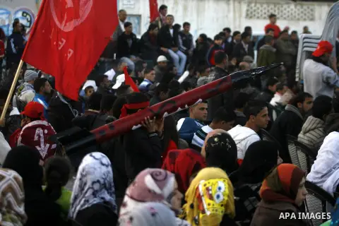 A Palestinian youth carries a model of a locally made rocket during a rally organized by the Popular Front for the Liberation of Palestine (PFLP) to mark the 45th anniversary of the founding of the PFLP in Khan Younis so...