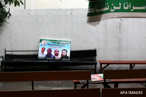 Supporters of Democratic Front for the Liberation of Palestine (DFLP) hold flags and portraits of Palestinian prisoners held in Israeli jails during a rally calling for their release, in Gaza city on Dec. 13, 2012. Photo...