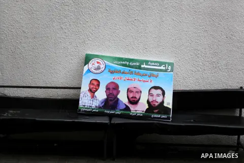 Supporters of Democratic Front for the Liberation of Palestine (DFLP) hold flags and portraits of Palestinian prisoners held in Israeli jails during a rally calling for their release, in Gaza city on Dec. 13, 2012. Photo...