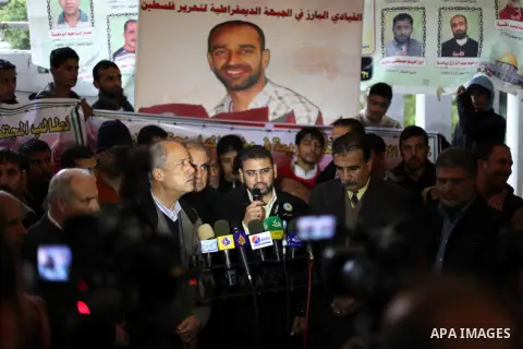 The spokesman of Hamas, Sami Abu Zuhri during a press conference in Gaza city on Dec. 13, 2012. Supporters of Democratic Front for the Liberation of Palestine (DFLP) hold flags and portraits of Palestinian prisoners held...