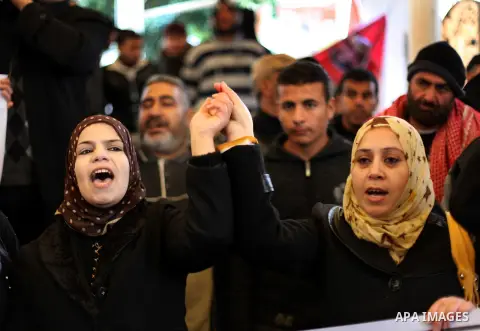 Supporters of Democratic Front for the Liberation of Palestine (DFLP) hold flags and portraits of Palestinian prisoners held in Israeli jails during a rally calling for their release, in Gaza city on Dec. 13, 2012. Photo...