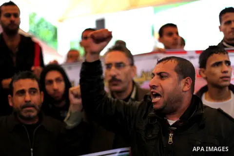 Supporters of Democratic Front for the Liberation of Palestine (DFLP) hold flags and portraits of Palestinian prisoners held in Israeli jails during a rally calling for their release, in Gaza city on Dec. 13, 2012. Photo...