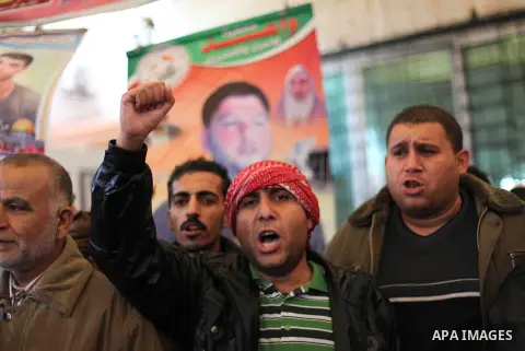 Supporters of Democratic Front for the Liberation of Palestine (DFLP) hold flags and portraits of Palestinian prisoners held in Israeli jails during a rally calling for their release, in Gaza city on Dec. 13, 2012. Photo...