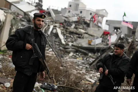 Palestinian security officers stand in front of rubbles while Qatari ambassador Mohammed al-Imadi visits bombed areas after the launching ceremony of Qatari grant projects in Gaza city on 13 Dec, 2012. The emir of Qatar...