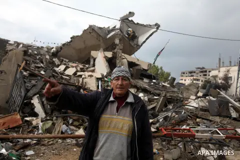 A Palestinian man stands in front of rubbles while Qatari ambassador Mohammed al-Imadi visits bombed areas after the launching ceremony of Qatari grant projects in Gaza city on 13 Dec, 2012. The emir of Qatar Sheikh Hama...