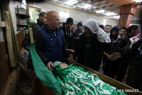 Relatives of Palestinian teenager Mohammed Ziad Salaymeh mourn next to his dead body during the funeral in the West Bank city of Hebron, 13 December 2012. Israeli border police in the divided West Bank city of Hebron on...