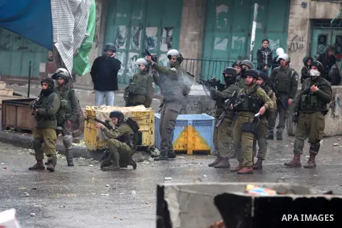Israeli soldiers shoot a tear gas grenade at Palestinian protesters during clashes in the West Bank city of Hebron, 13 December 2012. The clashes broke out before the funeral of Palestinian teenager Mohammed Ziad Salayme...