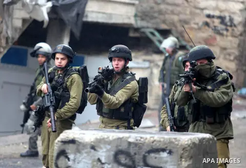 Israeli soldiers shoot a tear gas grenade at Palestinian protesters during clashes in the West Bank city of Hebron, 13 December 2012. The clashes broke out before the funeral of Palestinian teenager Mohammed Ziad Salayme...