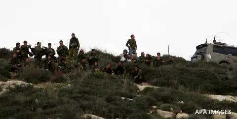 Israeli soldiers walk before clashes broke out with Palestinian protestors during a demonstration against the expropriation of Palestinian land by Israel in the village of Kfar Qaddum, near the occupied West Bank city of...