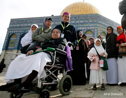 Palestinian and foreign worshippers walk in front of the Dome of the Rock mosque following Friday prayer at al-Aqsa mosque, Islam's third holiest site, on December 14, 2012, in the old city of Jerusalem. Photo by Mahfouz...