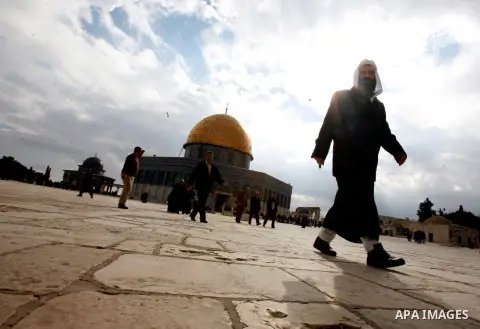 Palestinian and foreign worshippers walk in front of the Dome of the Rock mosque following Friday prayer at al-Aqsa mosque, Islam's third holiest site, on December 14, 2012, in the old city of Jerusalem. Photo by Mahfouz...