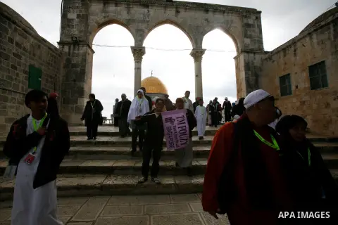 Palestinian and foreign worshippers walk in front of the Dome of the Rock mosque following Friday prayer at al-Aqsa mosque, Islam's third holiest site, on December 14, 2012, in the old city of Jerusalem. Photo by Mahfouz...