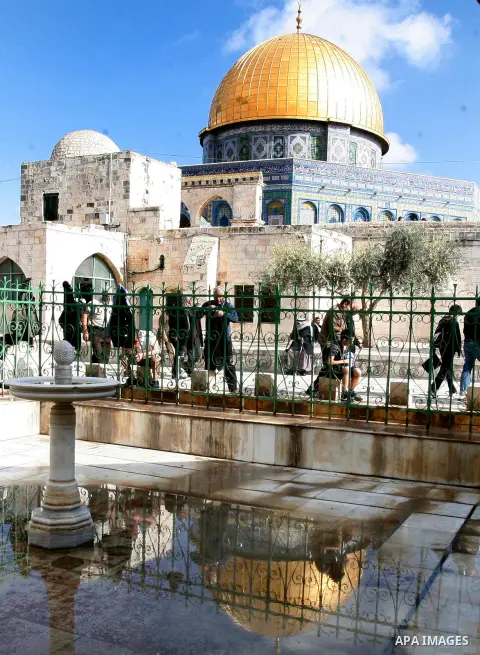 Palestinian and foreign worshippers walk in front of the Dome of the Rock mosque following Friday prayer at al-Aqsa mosque, Islam's third holiest site, on December 14, 2012, in the old city of Jerusalem. Photo by Mahfouz...