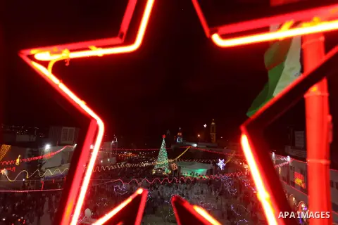 Palestinians celebrate the lighting of the Christmas tree in Manger Square, outside the Church of the Nativity, in the West Bank biblical town of Bethlehem, the traditional birthplace of Jesus as preparations for Christm...